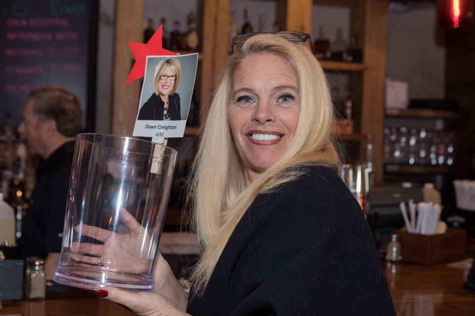 Patron holding tip jar for Celebrity Bartender event