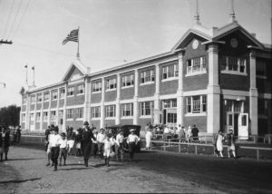 Historical photo of students walking out of school