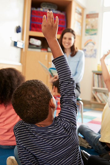 Boy raising hand in classroom