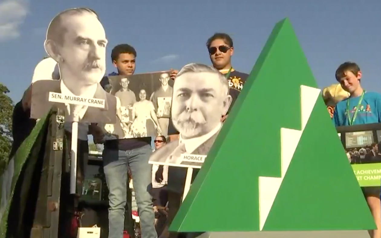 JA kids hold life size JA historical poster cutouts