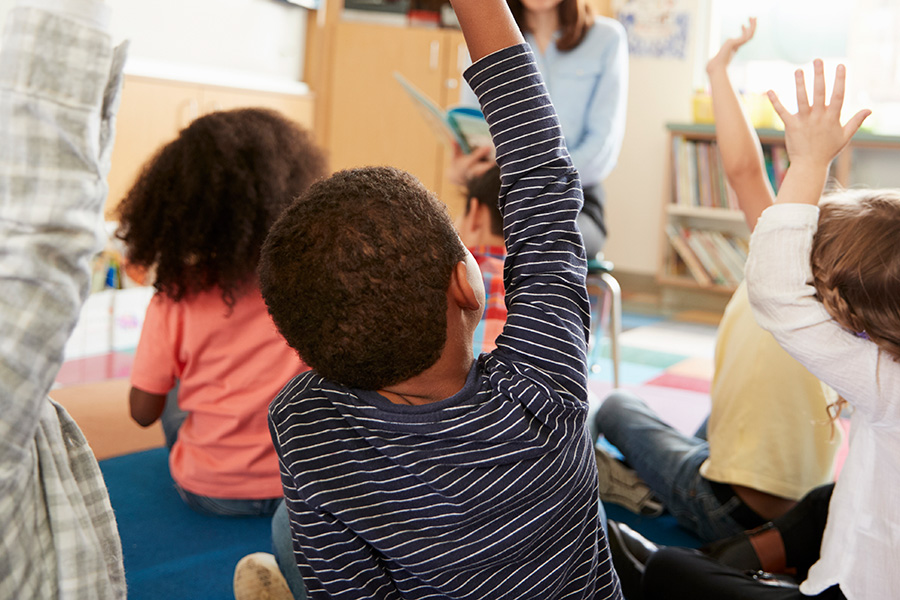 kids raising hands in class