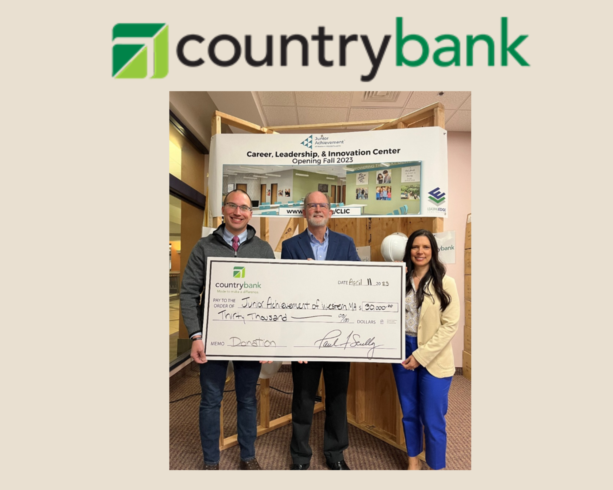 Three people holding an oversized check in front of the Career, Leadership, & Innovation Center sign